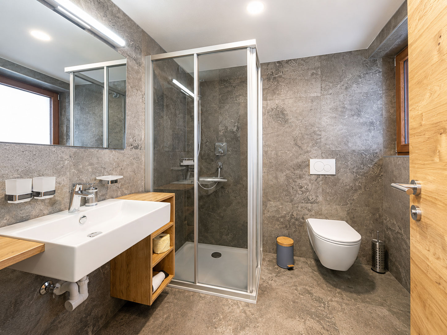 Modernes Bad des Doppelzimmers mit Dusche, Waschtisch und WC