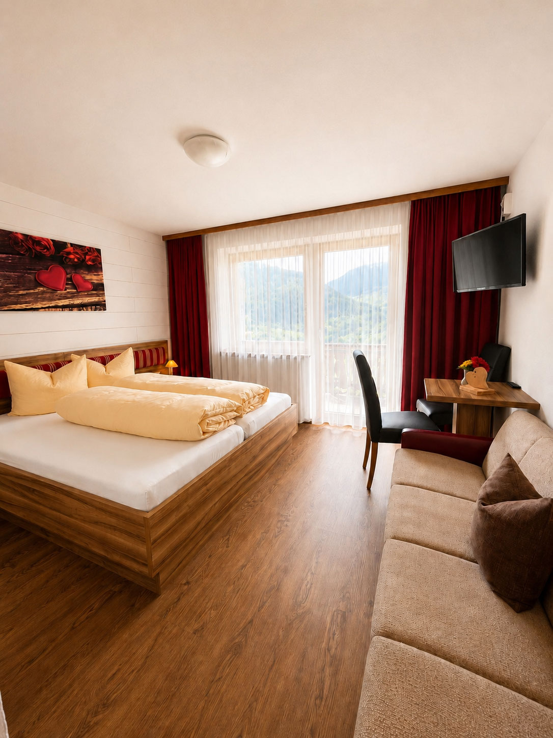 Dreibettzimmer mit Doppelbett, Couch und Balkonfenster